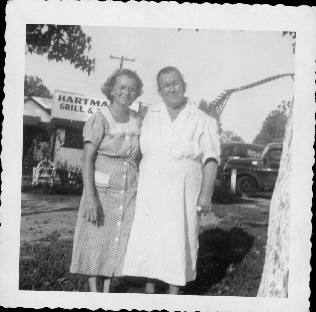 Two women in front of the Hartman's Grill and Tavern sign